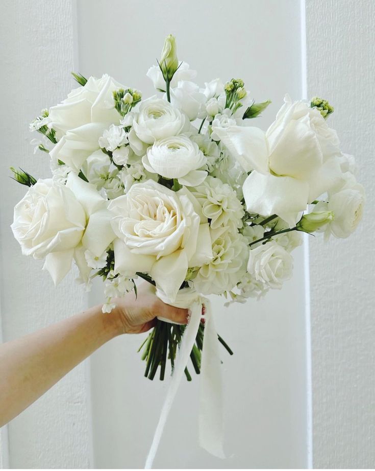 a person holding a bouquet of white flowers