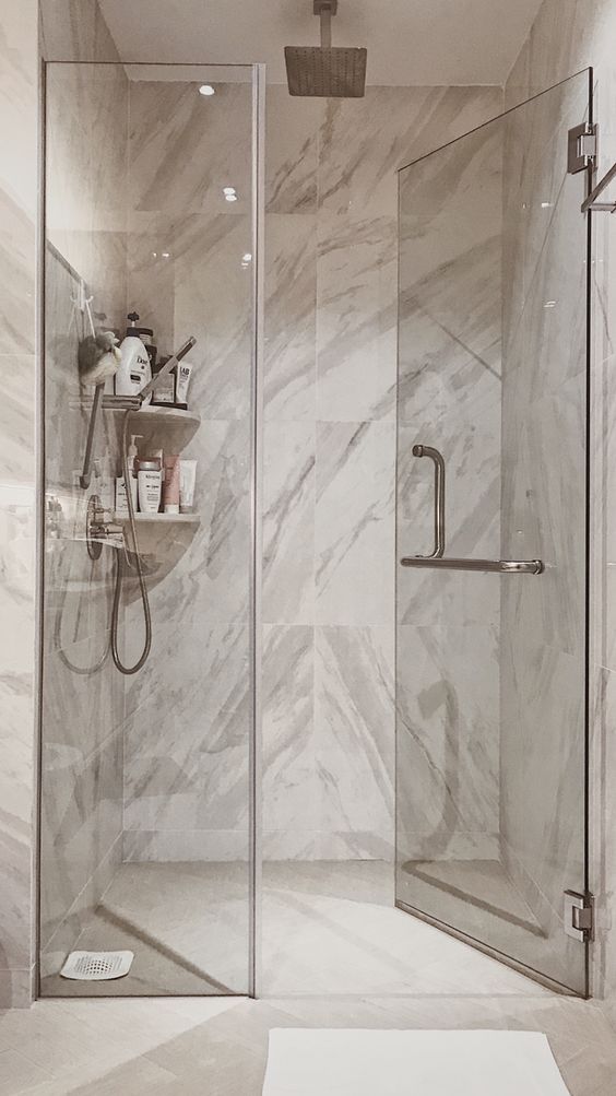 a walk in shower sitting inside of a bathroom