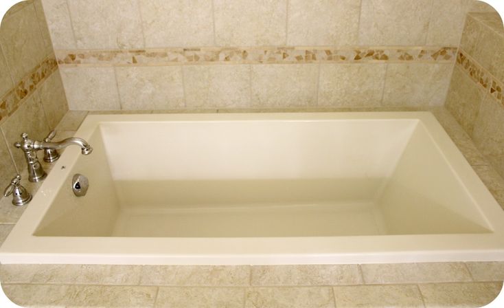 a white bath tub sitting inside of a bathroom next to a shower head and faucet