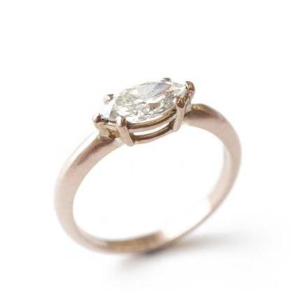 an engagement ring with a pear shaped diamond in the center, on a white background