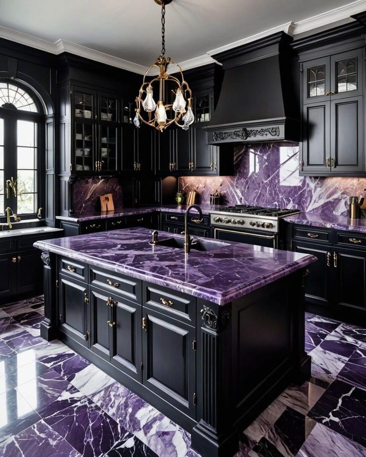 a large kitchen with black cabinets and purple marble counter tops, along with a chandelier hanging from the ceiling