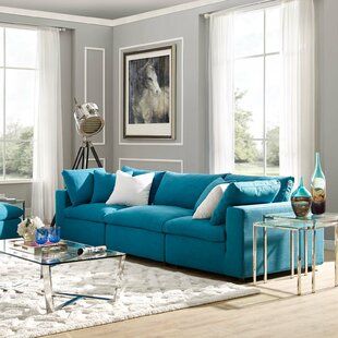 a living room with blue couches and coffee table in front of two large windows