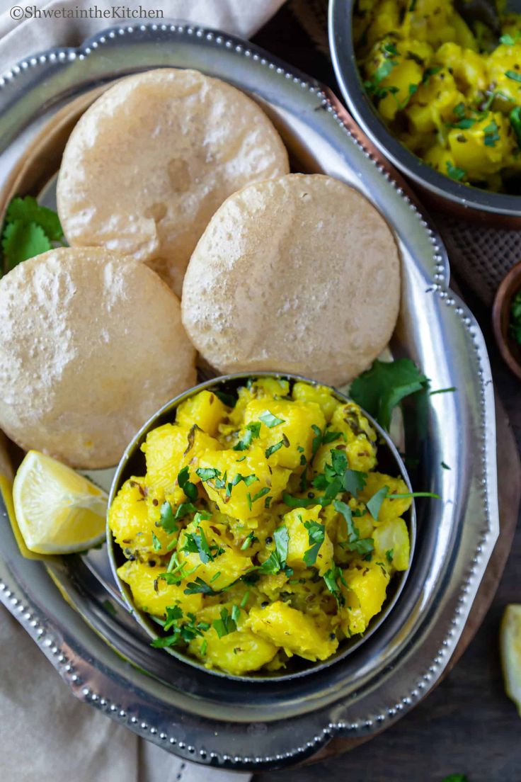 some food that is in a bowl on a table with lemons and other foods