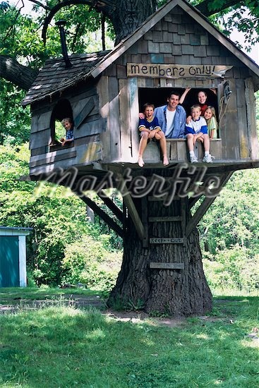 the family is sitting in the tree house