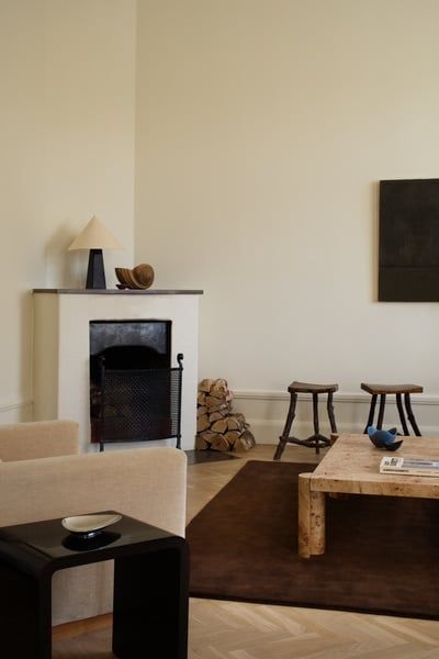 a living room filled with furniture and a fire place next to a painting on the wall