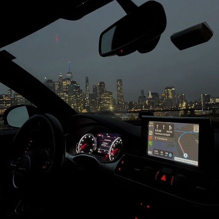 the interior of a car with city lights in the background