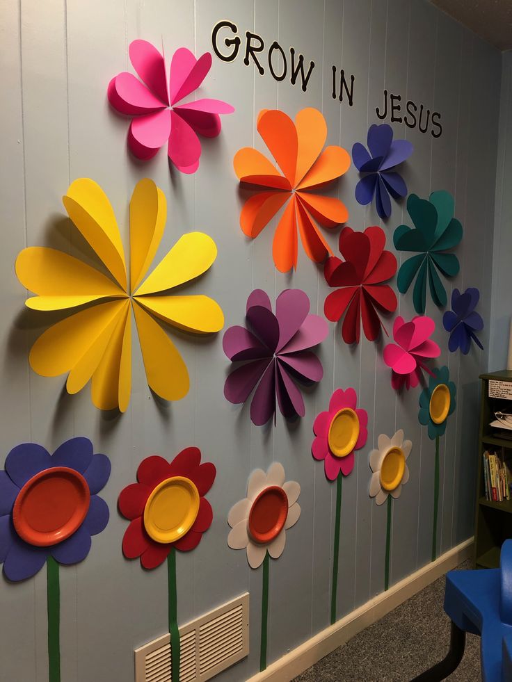 colorful paper flowers are arranged on the wall