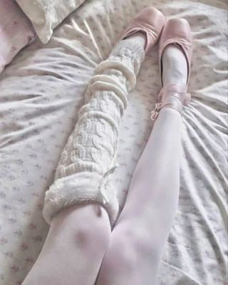 a woman laying on top of a bed with her legs wrapped in a blanket and shoes