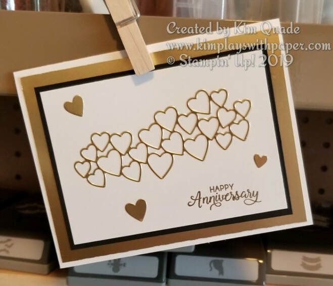 a happy anniversary card with hearts hanging from a clothes line on a shelf in a store