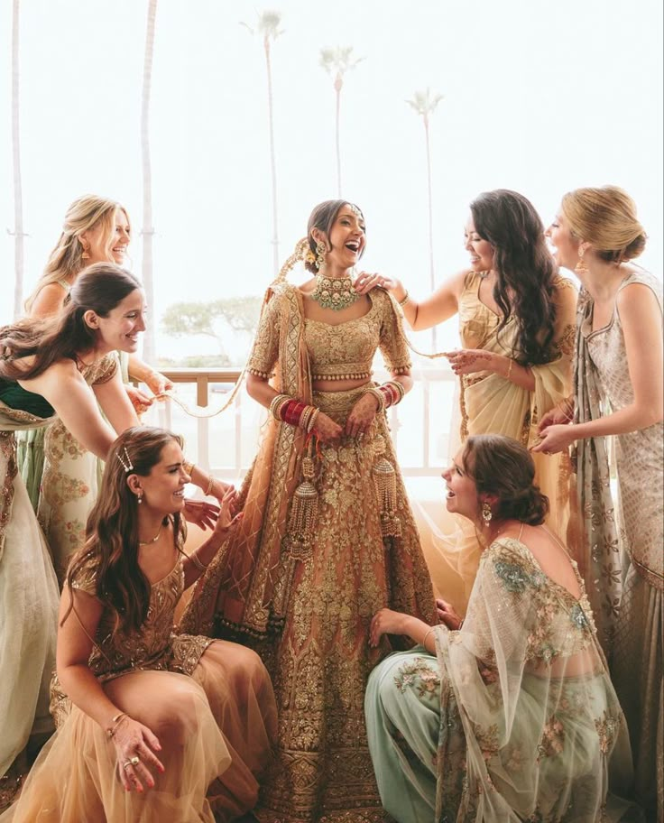 a group of women standing next to each other in front of a window with palm trees