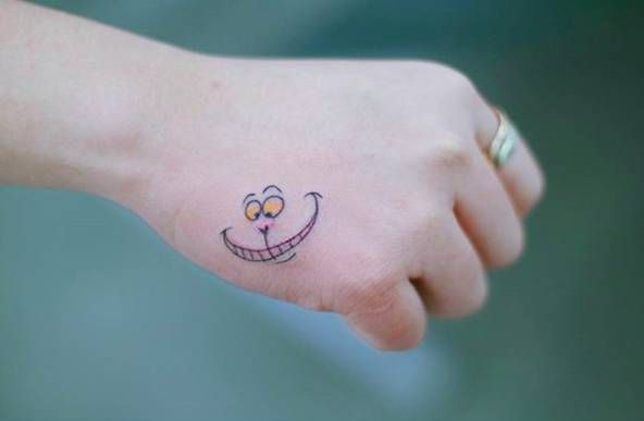 a hand with a smiley face tattoo on it