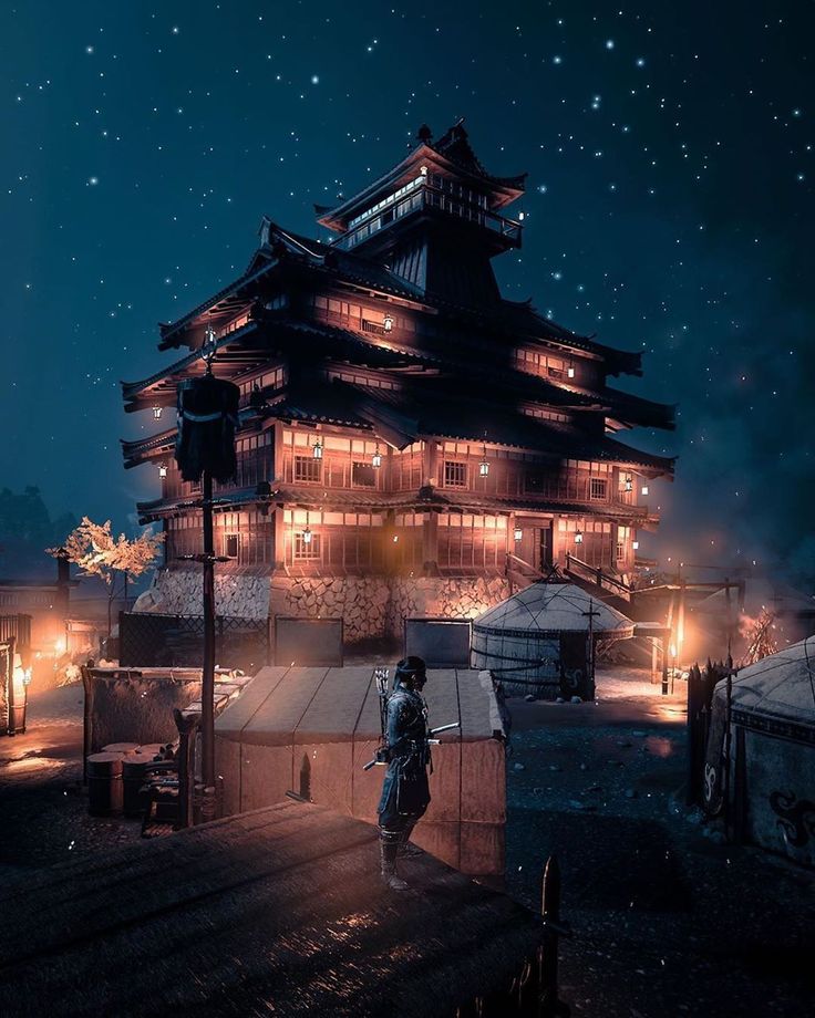 a person standing in front of a tall building at night with lights on the roof