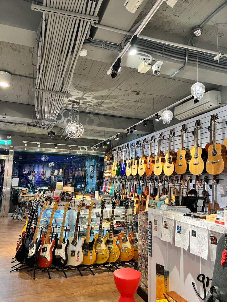 guitars are lined up on the wall in this music store