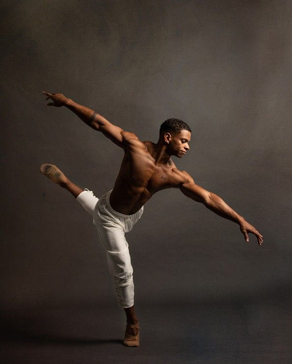 a man in white pants and no shirt is doing a kickbox pose with his arms out