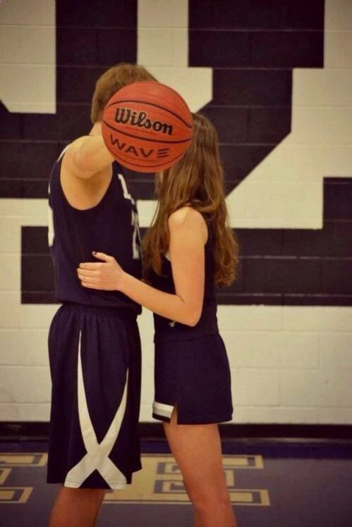 two girls are playing basketball in the gym