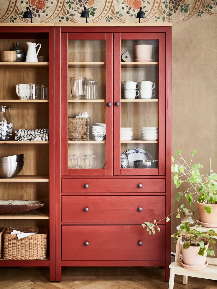 a red china cabinet with glass doors and drawers