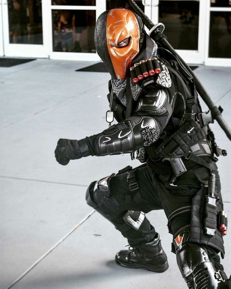 a man dressed in black and orange is posing for the camera