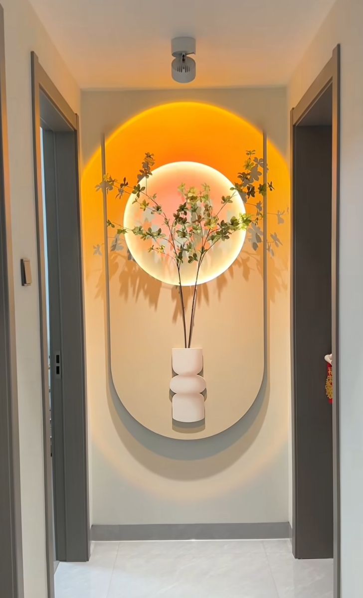 there is a vase with flowers in it on the wall next to an entrance way