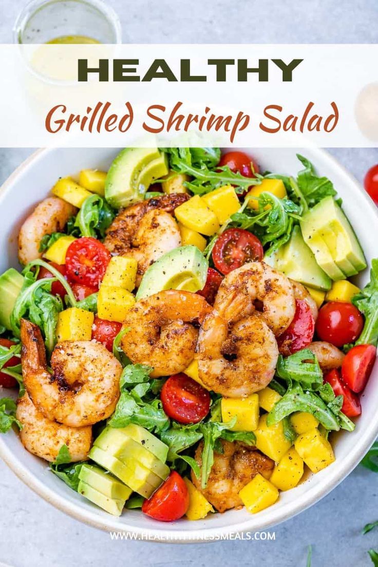 shrimp salad with avocado, cherry tomatoes and cucumber in a white bowl