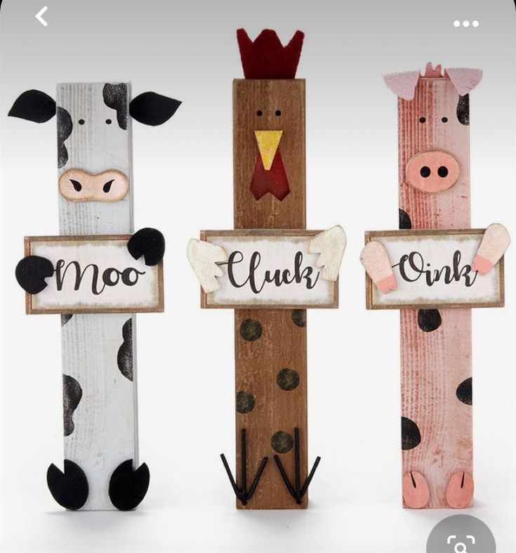 three wooden signs with farm animals on them and the words moo, cluck, cow