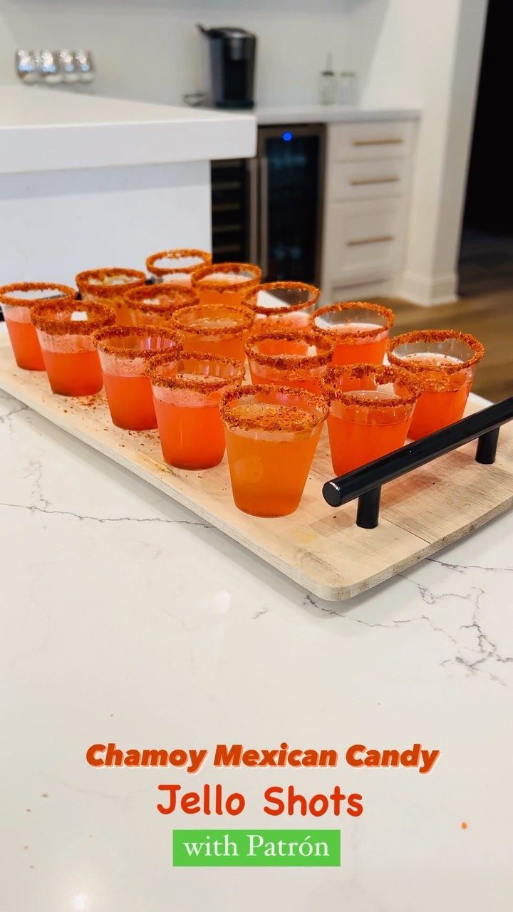 there are many glasses on the tray with jello shots in each glass and one is orange