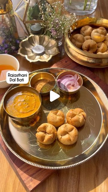 some food is sitting on a silver plate and there are bowls with dips in them