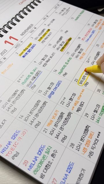 a person is writing on a calendar with yellow marker