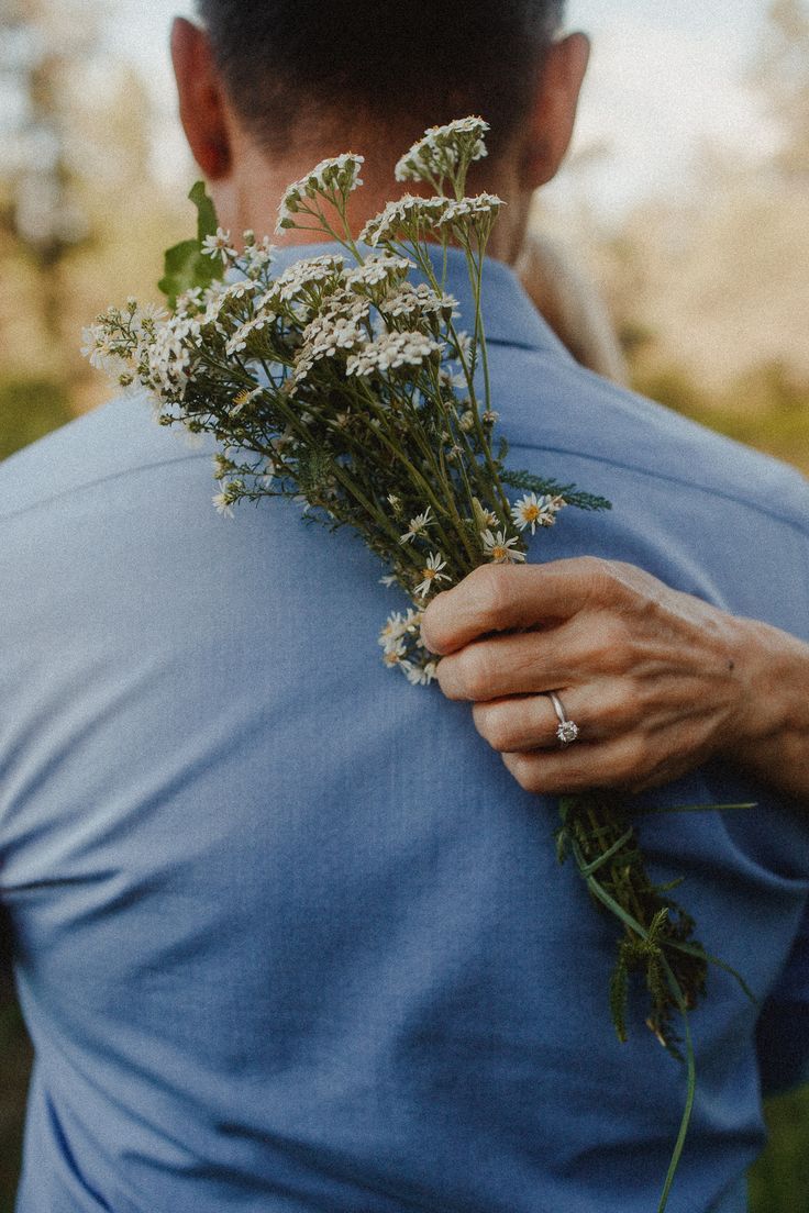 a man is holding flowers in his hands