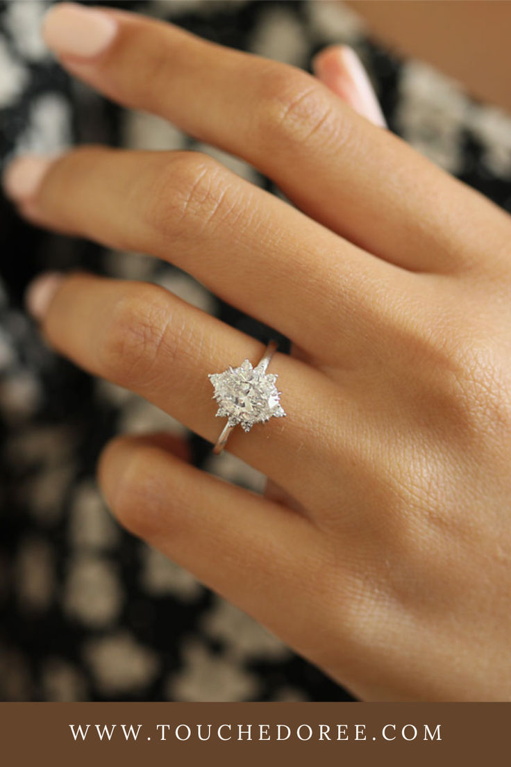 a woman's hand with a diamond ring on it