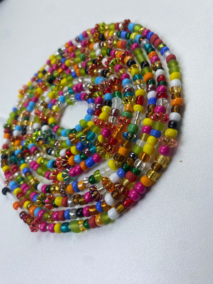 Brighten your life and wardrobe with our stunning Multicolored Waistbead. Handcrafted with love, each bead is carefully selected and strung to create a vibrant, eye-catching accessory that complements any outfit. Uses of the Multicolored Waistbead: • Fashion Statement: Wear it over or under your clothing to add a pop of color and a touch of elegance to your ensemble. • Body Awareness: Helps you stay mindful of your body, serving as a gentle reminder of your fitness and wellness journey. • Weight Multicolor Round Waist Beads For Beach, Multicolor Waist Beads For The Beach, Multicolor Waist Beads For Beach, Multicolor Beaded Chain Waist Beads For Festivals, Colorful Adjustable Beaded Necklaces With Polished Beads, Spiritual Multicolor Waist Beads With Tiny Beads, Colorful Adjustable Beaded Necklace With Polished Beads, Adjustable Multicolor Beaded Chain Waist Beads, Adjustable Multicolor Waist Beads With Large Beads