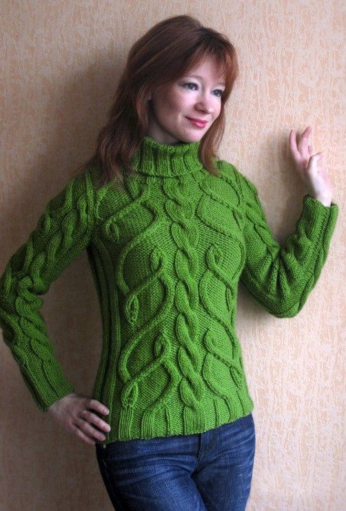 a woman wearing a green sweater and jeans posing for the camera with her hands on her hips