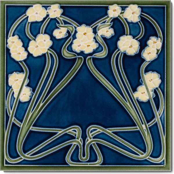 a blue and green tile with white flowers in the shape of a flower vase on it's side