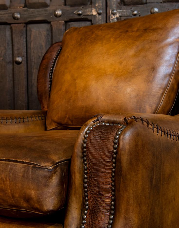 a brown leather reclining chair with nail polishing on the armrests and foot rest