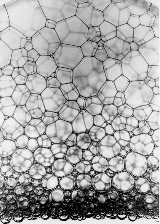 a close up view of a net with water droplets on the mesh and light reflecting off it