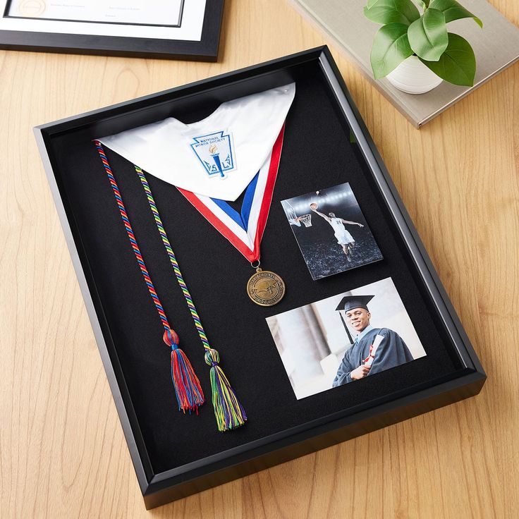 a graduation gift box with an old photo, medal and other items on the table