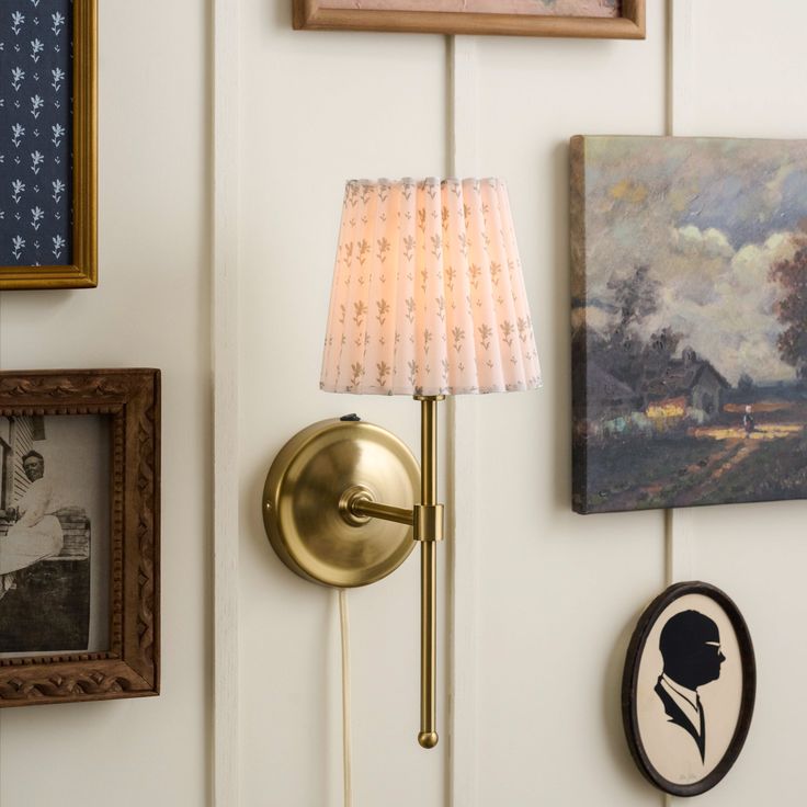 a wall with pictures and lamps on it