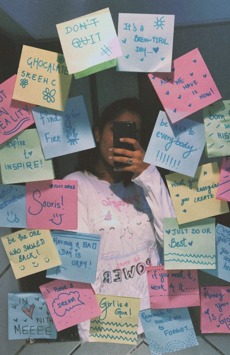 a woman holding a cell phone surrounded by post it notes