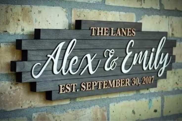 a wooden sign that says the lanes, alex & envyy estt, and is hanging on a brick wall