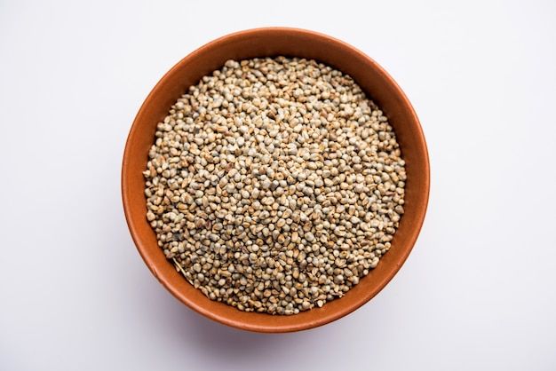 a brown bowl filled with seeds on top of a white table