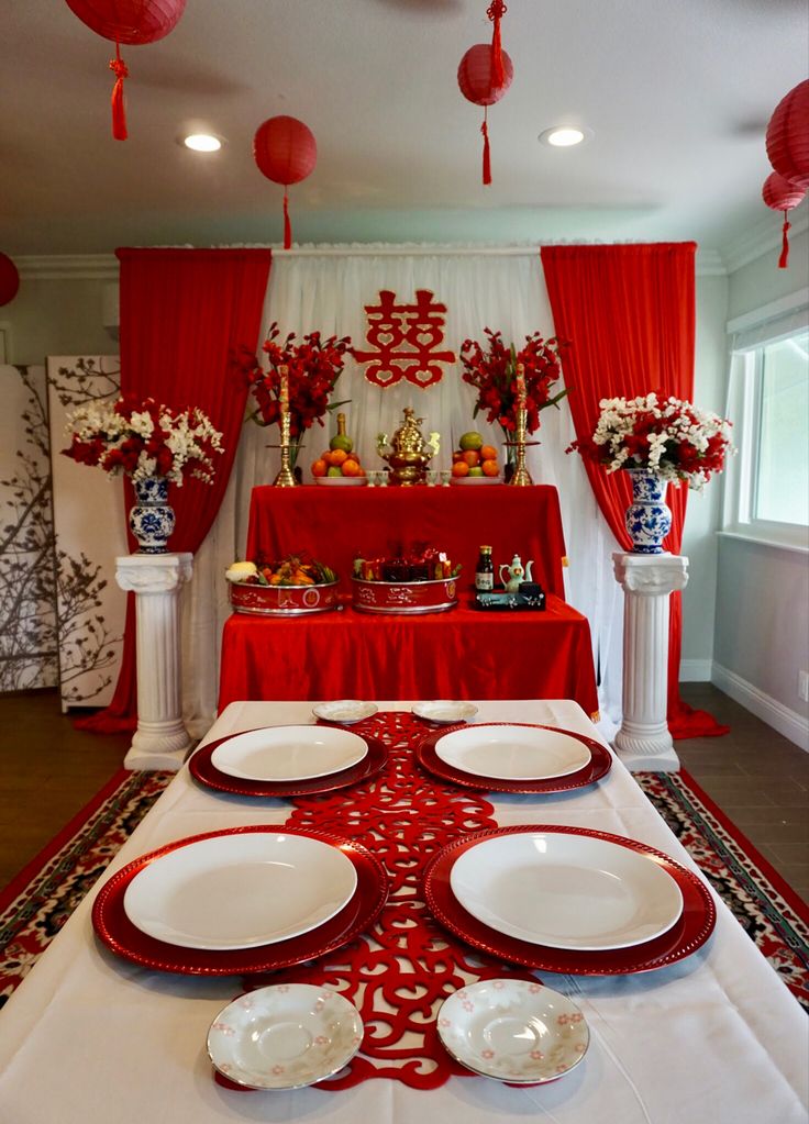 the table is set with red and white plates