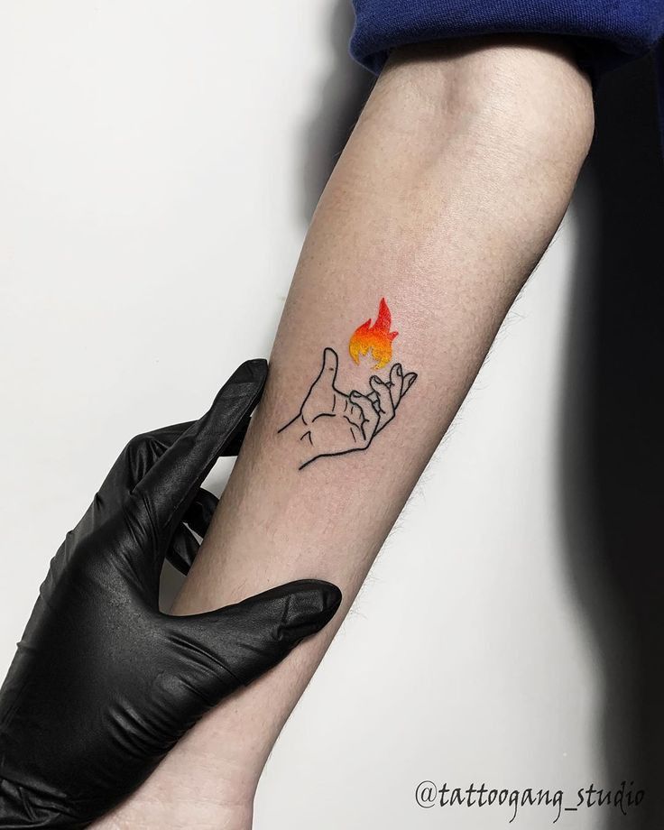 a woman's arm with a tattoo on it that has a hand holding a flame