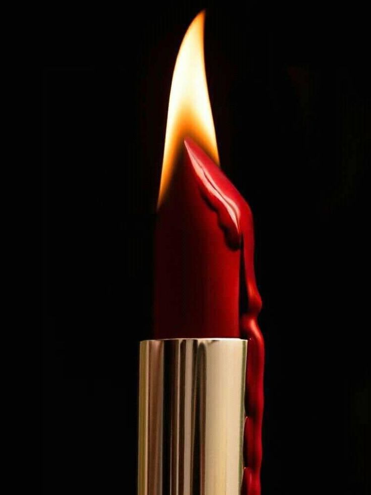 a close up of a red candle with a flame coming out of it's center