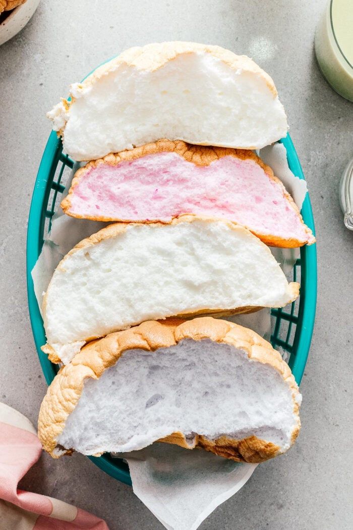 there are three sandwiches in the basket on the table, one with meat and cheese