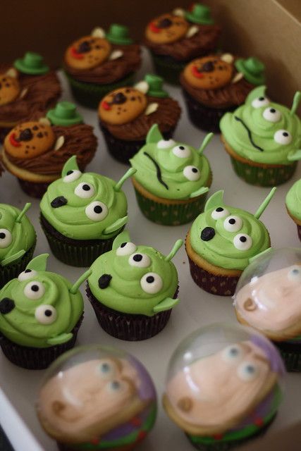 some cupcakes with green frosting and googly eyes are in a box