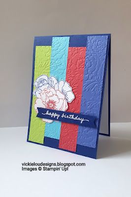 a birthday card with a flower on the front and blue, green, red, yellow, and orange stripes