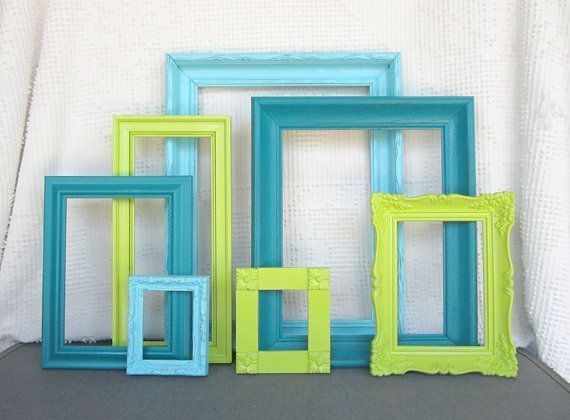 four different colored frames sitting next to each other on a table with a white wall in the background