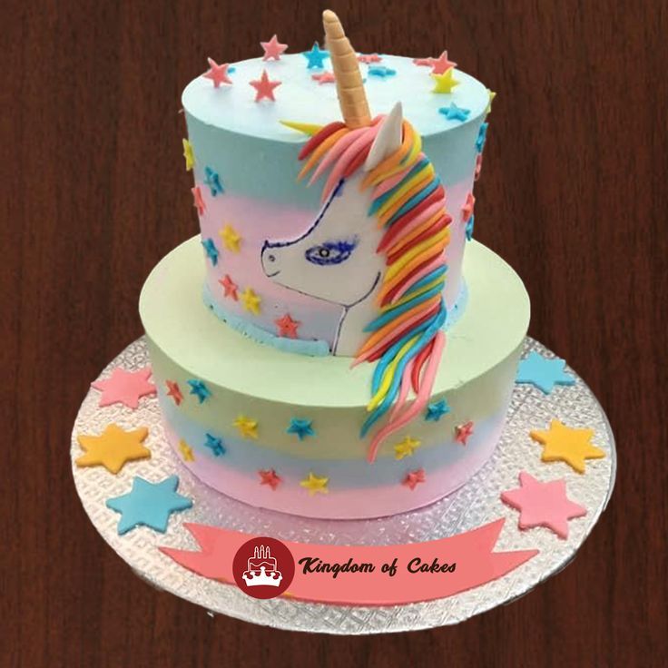 two cakes decorated with unicorns and stars on top of each other, sitting on a table