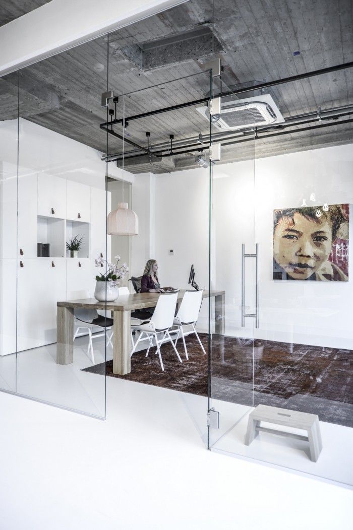 an office with glass walls and pictures on the wall