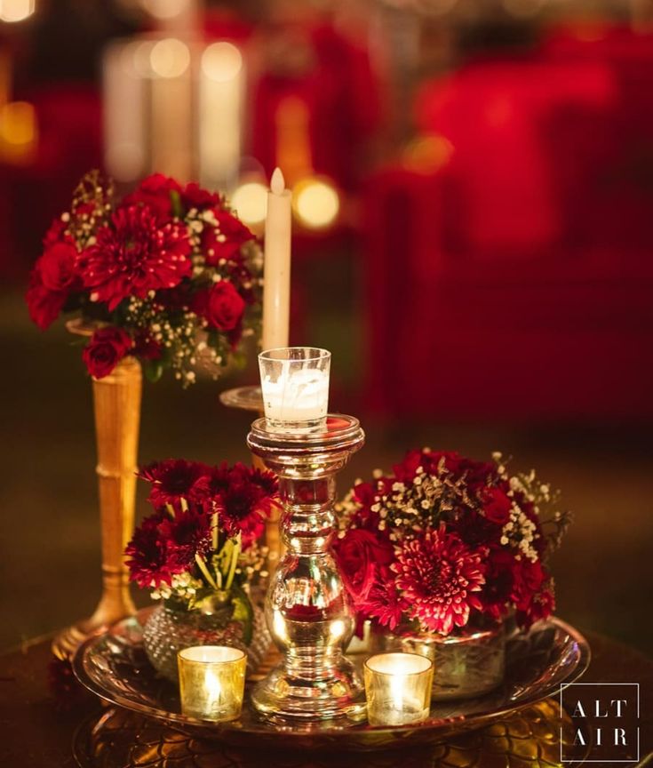 candles and red flowers on a tray