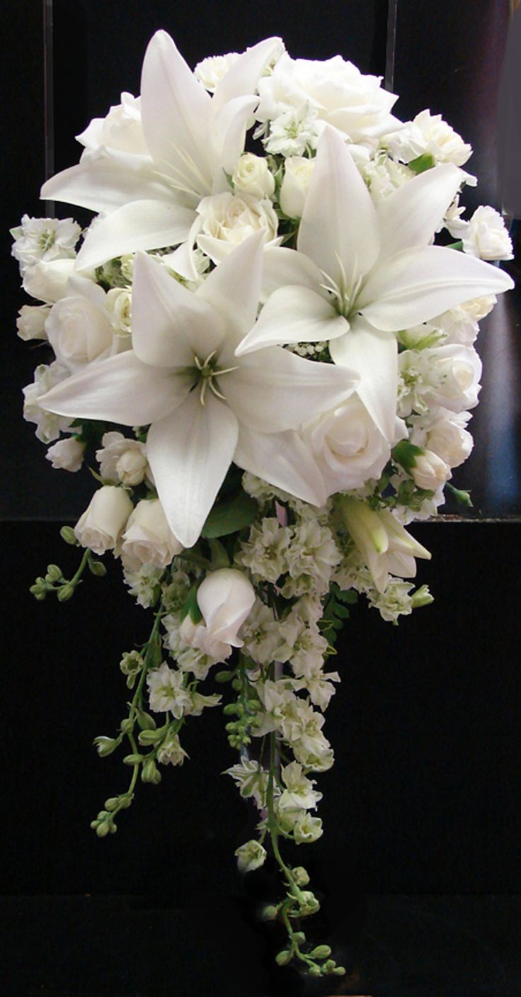 white flowers and greenery are arranged in a bouquet